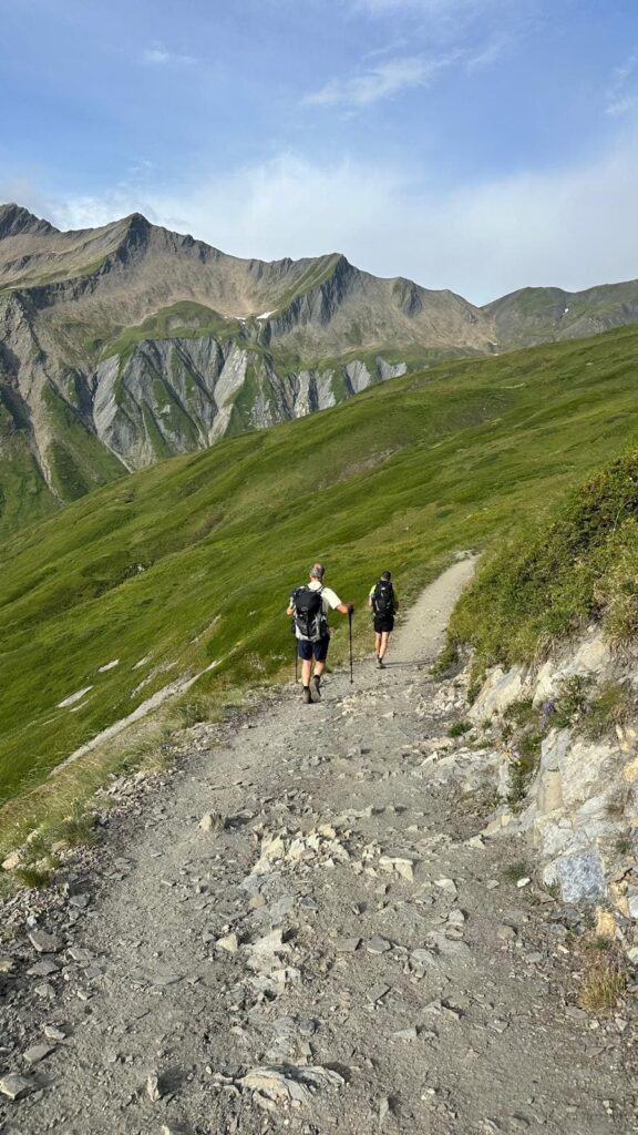 Randonneurs sur un sentier de crête face aux montagnes du Tour du Mont Blanc