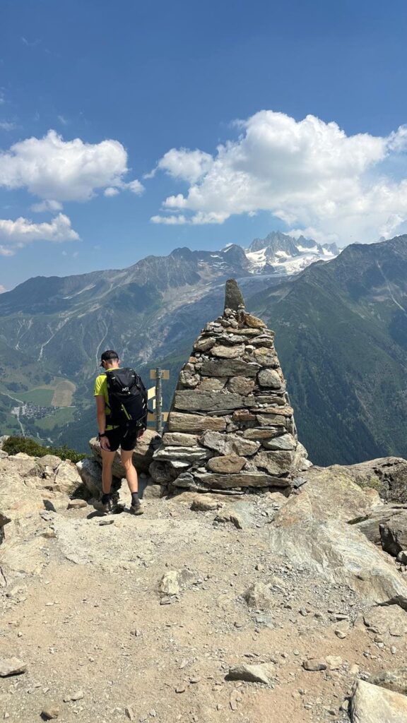 Randonneur près d'un cairn en haute montagne sur le Tour du Mont Blanc